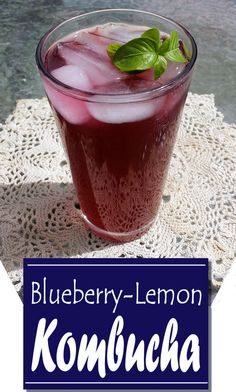 a blueberry lemon kombucha is served in a glass on a doily