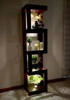 a tall shelf with plants in it on top of a carpeted floor next to a wall