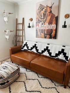 a living room with a leather couch and cow skull decor on the wall behind it