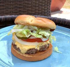 a cheeseburger with lettuce and tomato on a blue plate