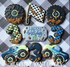 decorated cookies are arranged in the shape of numbers and cars on a checkered tablecloth