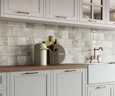 a kitchen with white cabinets and wooden counter tops