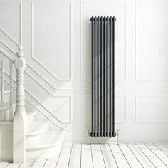 an image of a bathroom setting with white walls and flooring that has a black radiator