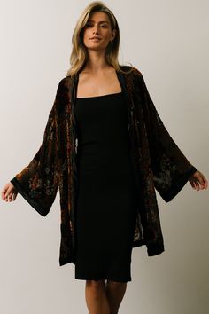 Baltic Born exclusive style! Black with bronze, deep red, and forest green floral Burnout velvet material with a velvet border Open front style Long kimono sleeves with velvet cuffs Slits on both sides 100% Polyester Skye is 5'9, cup size 32A, size 0 and wearing size S Jayci is 5'8", cup size 38 DD, and wearing size 1XL Black Velvet Kimono, Green Velvet Kimono, Witchy Work Outfit, Forest Wedding Outfit, Woodsy Fashion, Black Boho Outfits, Edgy Vintage Outfits, Sheer Kimono Outfit, Witchy Fashion Modern Witch