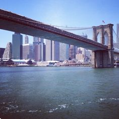 a bridge over the water with tall buildings in the background