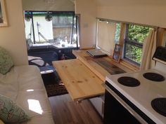 a tiny kitchenette in the back of a camper with a table and stove