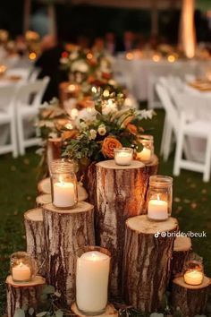 a table with candles and flowers on it is set up in the middle of a field