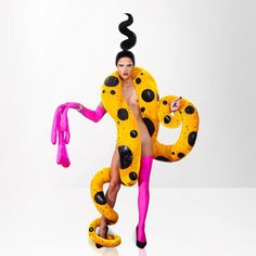 a woman in a costume made to look like a snake with black spots and pink tights