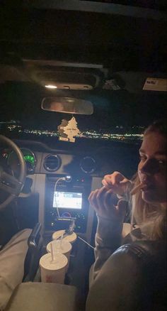 a woman sitting in the driver's seat of a car