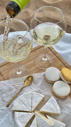 cheese, crackers and wine are sitting on a table with white paper under them