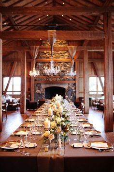 a long table is set up with place settings and candles for an elegant wedding reception