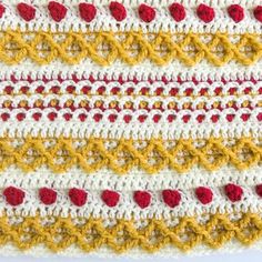 a crocheted blanket with red, yellow and white stripes on the edges is shown