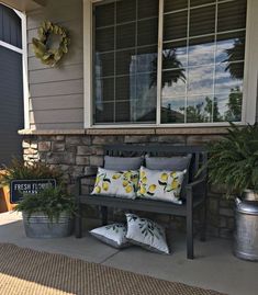 a bench sitting on the side of a house next to potted plants