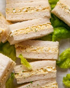 several sandwiches cut in half on top of lettuce