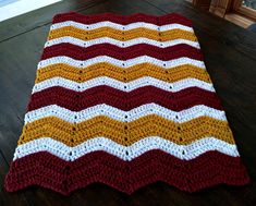 a crocheted blanket sitting on top of a wooden floor