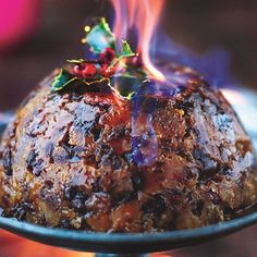 a christmas pudding on a plate with holly decorations