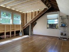 an unfinished room with wood floors and windows