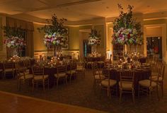 a banquet room set up with tall centerpieces and floral arrangements