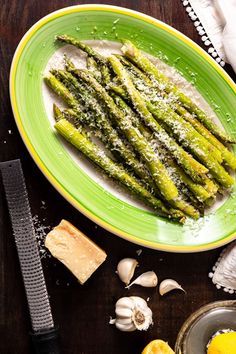 asparagus on a plate with parmesan cheese and garlic next to it