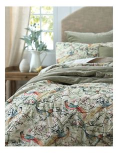 the comforter is made up with birds on it