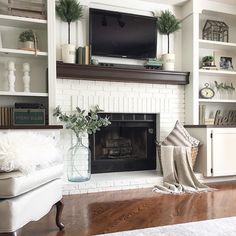 a living room filled with furniture and a flat screen tv mounted above a fire place