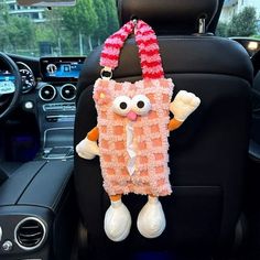 a stuffed animal hanging from the back seat of a car