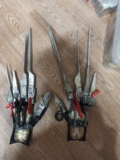 two pairs of pliers are sitting on the floor next to each other with tools in them