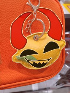 a close up of a bag with a key chain attached to it's face