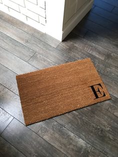 a door mat with the letter f on it in front of a doorway and floor