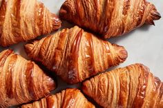 several croissants sitting on top of a white counter next to each other