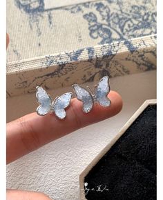 a person is holding some kind of ring in their hand and it has two butterflies on it