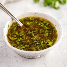 a white bowl filled with broccoli soup on top of a table