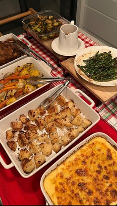 a table topped with lots of different types of food on trays next to each other