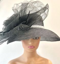 The featured hat is a very dramatic and gorgeous black straw mesh hat with some silver metallic threading running through the whole hat giving the black hat a bit of sparkle. The hat has a curved downward turned brim. A sparkly band with encrusted silver beads goes around the base of the hat. The hat is adorned with a very very large black crinoline disc with a center flower and accent black feathers. This hat is so dramatic and gorgeous and the good news is that there was only one hat made in t Black Cloche Party Hat, Black Straw Hat For Summer Party, Black Boater Hat For Kentucky Derby Evening, Black Summer Hat For Wedding, Black Boater Hat For Summer Wedding, Black Summer Wedding Hat, Summer Black Wedding Hat, Summer Wedding Black Hat, Evening Fedora Straw Hat For Kentucky Derby