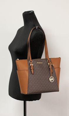 Style: Michael Kors Charlotte Handbag Tote (Brown Signature) Material: PVC/Leather Features: MK Logo on Front, Zip Closure, MK logo charm, Exterior Pocket Measures: 10" L x 15" W x 4.5" D MSRP: $398 Luxury Tote Bags Michael Kors, Michael Kors Shopper Bag, Michael Kors Brown Tote, Cheap Michael Kors Rectangular Shoulder Bag, Cheap Rectangular Michael Kors Shoulder Bag, Brown Tote Shoulder Bag With Logo, Brown Shoulder Bag With Logo For Everyday, Brown Logo Tote Shoulder Bag, Brown Logo Shoulder Bag For Daily Use