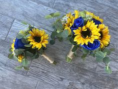 two bouquets of sunflowers and blue roses are on the floor next to each other