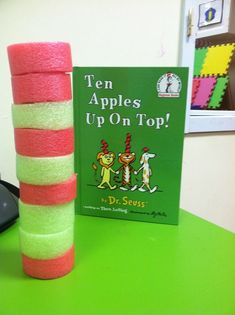 a stack of books sitting on top of a green table next to a stack of sponges