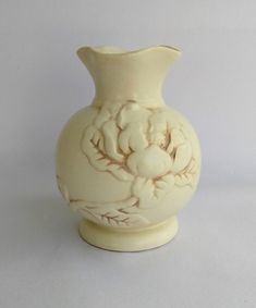 a white vase sitting on top of a table