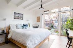 a bedroom with white walls and wood floors