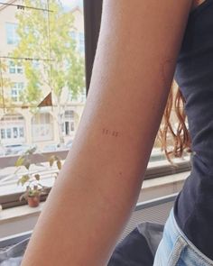 a woman's arm with the word love written on it, in front of a window