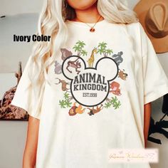 a woman wearing an animal kingdom tshirt in front of a wall with the words ivory color on it