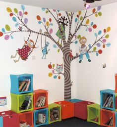 children's playroom with colorful bookshelves and tree mural