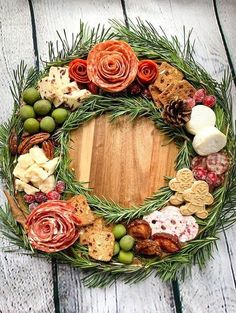 a wreath made out of different types of food on a wooden surface with pine cones and berries