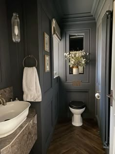 a white toilet sitting in a bathroom next to a sink