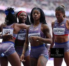 three women in sports bras and shorts standing next to each other on a track