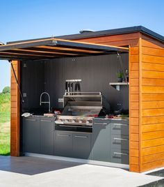 an outdoor kitchen is built into the side of a building with a grill in it