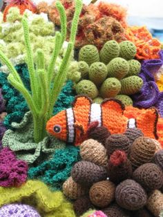 an assortment of crocheted sea animals and corals on display in a store