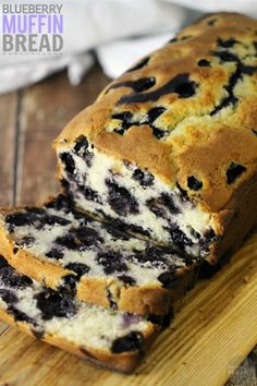 a loaf of blueberry muffin bread sitting on top of a wooden cutting board