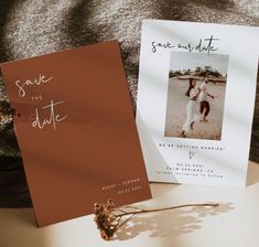 two wedding save the dates cards on top of a bed next to an envelope and flower