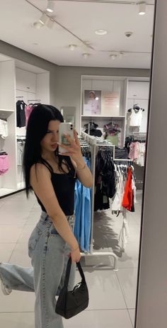 a woman taking a selfie in a clothing store